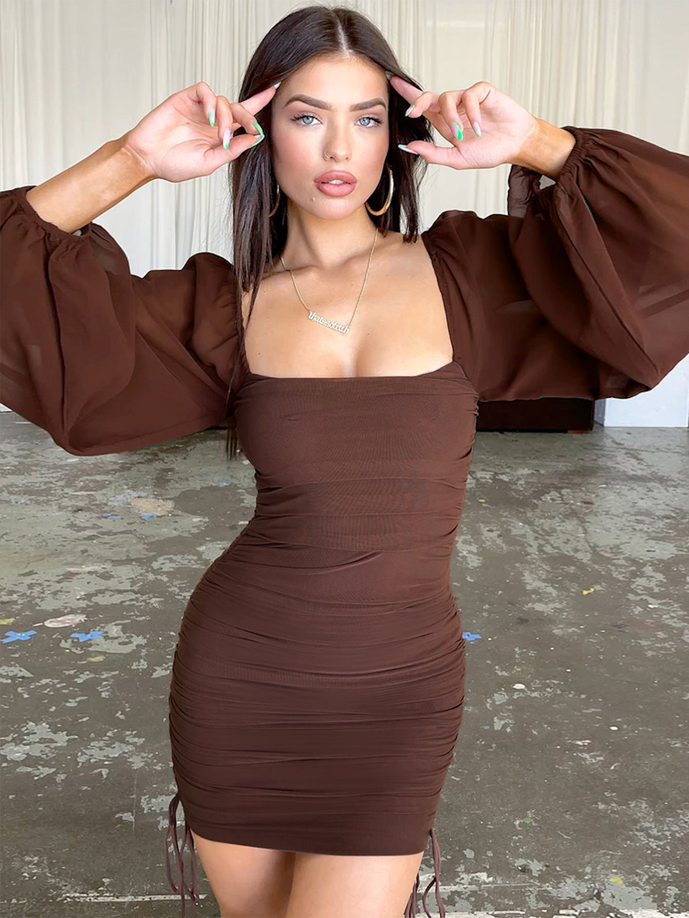 Abito aderente plissettato con nodo traforato e scollo a V profondo